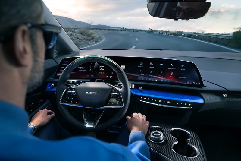 Front View of the 2026 OPTIQ-V Driving Through the Dusk Utilizing its Headlights | Watsonville Cadillac in Watsonville CA